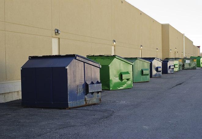 workers clearing construction waste into dumpsters in Jean